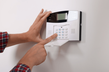 A man setting a home security alarm as part of comprehensive financial planning.